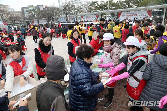 【창원=뉴시스】 홍정명 기자 = 21일 창원 마산역 앞에서 BNK경남은행 직원 및 자원봉사자들이 지역의 어르신을에게 사랑의 동지팥죽을 배식하고 있다.2018.12.21.(사진=BNK경남은행 제공) photo@newsis.com