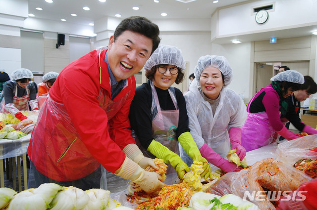 【창원=뉴시스】 홍정명 기자 = 21일 자유한국당 경남도당 5층 강당에서 열린 도당 여성위원회 주관 ‘사랑의 김장 나눔’ 행사에 참석한 윤영석 도당 위원장이 김장김치를 담고 있다.2018.12.21.(사진=자유한국당 경남도당 제공) photo@newsis.com