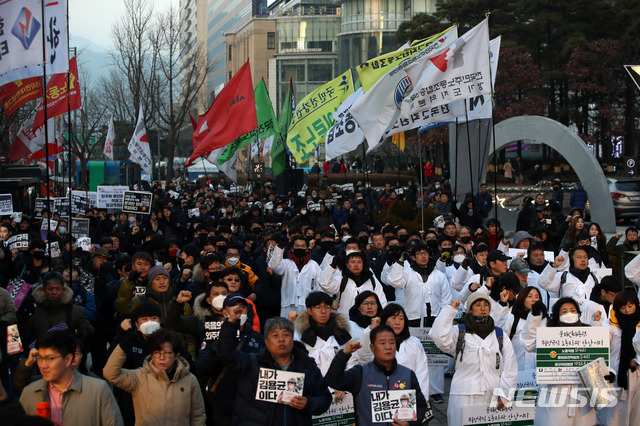 【서울=뉴시스】김선웅 기자 = 22일 오후 서울 중구 파이낸스센터 앞에서 열린 '태안화력발전소 비정규직 노동자 故 김용균 씨 추모 문화제'에서 참가자들이 고인을 추모하며 구호를 외치고 있다. 2018.12.22. mangusta@newsis.com