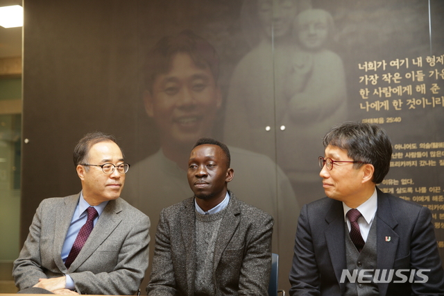 【김해=뉴시스】김상우 기자 = 인제대학교(총장 김성수)는 고(故) 이태석 신부 제자로 한국에 유학와 9년만에 의사고시에 합격한 남수단 청년 토마스 타반 아콧(33)씨를 24일 김해 모교로 초청해 격려했다. 사진 왼편 김성수 총장, 토마스씨, 이종태 의과대학장.  2018.12.24 (사진=인제대 제공)  photo@newsis.com