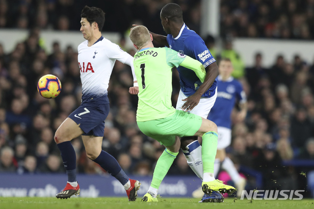 Everton goalie Jordan Pickford, center, collides with teammate Kurt Zouma, right, as Tottenham's Son Heung-min, left, scores during the English Premier League soccer match between Everton and Tottenham at Goodison Park Stadium, in Liverpool, England, Sunday, Dec. 23, 2018. (AP Photo/Jon Super)