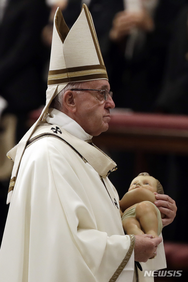 【바티칸시티= AP/뉴시스】프란치스코 교황이 24일(현지시간 ) 성베드로 성당에서 성탄절 전야 미사를 마친 뒤 아기 예수상을 안고 밖으로 나오고 있다.&nbsp;&nbsp;&nbsp; 