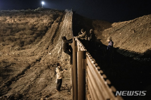 【샌디에이고=AP/뉴시스】미국 백악관과 민주당이 국경 예산 대치로 촉발된 미 정부 셧다운과 관련해 28일(현지시간) 상호 설전을 펼쳤다. 사진은 지난 25일 멕시코 티후아나에서 국경 펜스를 넘고 있는 이주민들. 2018.12.29.