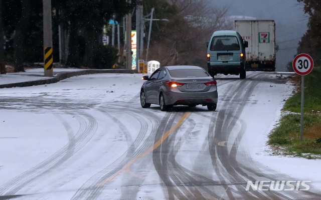 【제주=뉴시스】우장호 기자 = 제주 산간에 대설주의보가 발효 중인 28일 오전 차량들이 눈쌓인 제주시 노형동 인근 도로를 조심스럽게 통행하고 있다. 기상청에 따르면 29일 새벽까지 제주 산간에는 최고 20㎝가 넘는 많은 눈이 내릴 것으로 예보됐다. 2018.12.28.&nbsp; woo1223@newsis.com 
