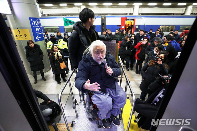 [서울=뉴시스]김병문 기자 = 박경석 전국장애인차별철폐연대 상임공동대표가 지난 2018년 12월28일 오후 서울 용산구 서울역에서 열린 '코레일 교통약자도우미서비스 규정=장애인차별규정 코레일 차별규정 현장 실측 및 진정 기자회견'을 마치고 KTX 열차 탑승까지 소요시간을 실측하기 위해 전동휠체어리프트를 사용하고 있다. 2018.12.28. dadazon@newsis.com