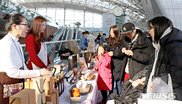 【인천공항=뉴시스】홍찬선 기자 = 인천공항공사는 지난 29일 인천공항 제1터미널 교통센터에서 소상공인 판로개척을 돕기 위한 플리마켓 ‘곳장 라이프 페어’를 개최했다. 곳장 라이프 페어에 참가한 시민들이 제품을 시음하고 있다. 2018.12.30.(사진=인천공항공사 제공) photo@newsis.com