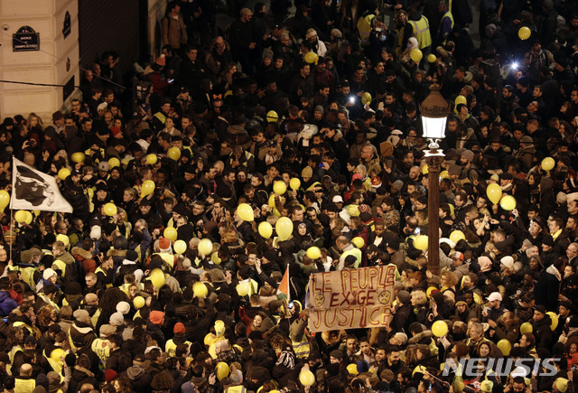【파리= AP/뉴시스】&nbsp; 파리 시내의 샹젤리제 거리에서 연례 신년전야 축제가 열리면서 노란조끼 시위대가 노란 풍선과 구호를 쓴 펼침막을 들고 평화행진을 하고 있다.&nbsp; 이날 시위대가 이곳에 집결하자는 공지를 소셜미디어를 통해 한 뒤에 경찰은 교통통제와 검문을 실시하는 등 이 일대에서 삼엄한 경비를 펼쳤다.&nbsp;&nbsp;&nbsp; 
