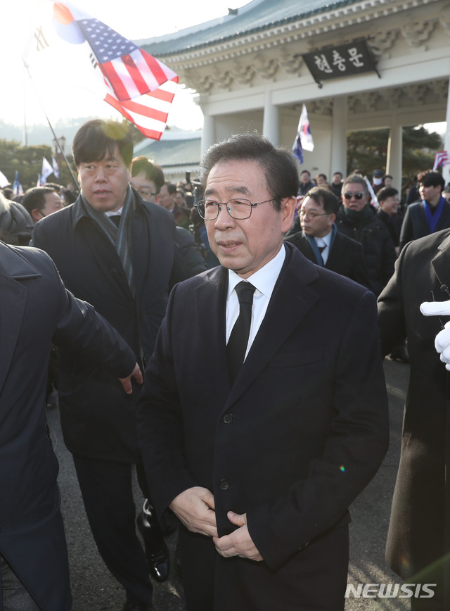 [서울=뉴시스]고승민 기자 = 지난 1월1일 오전 국립서울현충원 참배를 마친 박원순 서울시장이 태극기와 성조기를 든 대한애국당 당원들로부터 거센 고성을 들으며 현충원을 나서고 있다. 2019.01.01.photo@newsis.com
