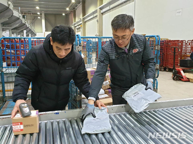 【서울=뉴시스】 추상철 기자 =강성주 우정사업본부장이 1일 오전 경기 성남우편집중국에서 직원과 함께 우편물 발송 작업을 하고 있다. 2019.01.01. (사진=우정사업본부 제공)photo@newsis.com