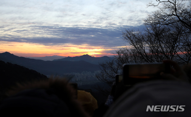 【서울=뉴시스】박미소 수습기자 = 2019 기해년 첫 날인 1일 오전 서울 도봉구 도봉산 천축사에서 바라본 해가 구름 사이로 떠오르고 있다. 2019.01.01. (사진=도봉구청 제공) photo@newsis.com