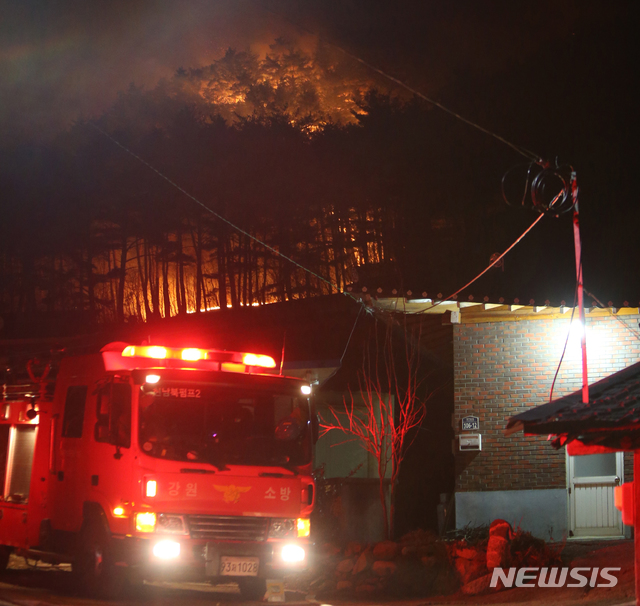 【양양=뉴시스】김경목 기자 = 2일 오전 4시 12시간째 산불이 번지고 있는 강원 양양군 서면 송천리 송천떡마을 뒷산이 붉은 화염으로 뒤덮이며 가옥을 덮칠 듯 위험해지자 소방차가 비상 대기하고 있다. 양양군에 따르면 오전 3시까지 약 13㏊의 산림이 잿더미가 됐지만 가옥 화재와 인명 피해는 발생하지 않았다. 2019.01.02.&nbsp; photo31@newsis.com 
