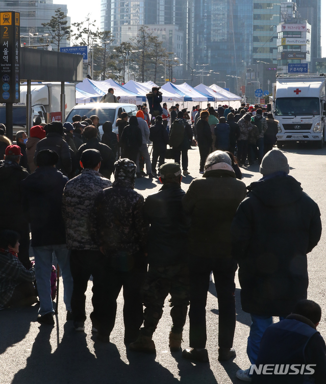 【서울=뉴시스】최진석 기자 = 2일 서울 중구 서울역 광장에서 열린 대한적십자사 시무식 겸 떡국 나눔 행사를 찾은 노숙인 및 인극 독거노인들이 줄지어 배식을 기다리고 있다.이날 행사에는 적십자 임직원과 봉사원 등 70여명이 참석하며, 오전 11시부터 급식차를 이용해 노숙인 및 인근 독거노인 등 약 500명에게 새해 떡국과 방한 귀마개를 제공했다. 2019.01.02.myjs@newsis.com