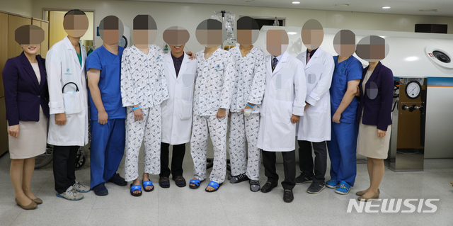 【강릉=뉴시스】김경목 기자 = 강릉아산병원 하현권 병원장(왼쪽부터 여덟 번째) 등 의료진들이 지난해 12월21일 강릉아산병원 고압산소치료실에서 살아남은 서울 대성고 학생 3명과 기념사진을 촬영하고 있는 모습. 2019.01.04. photo@newsis.com