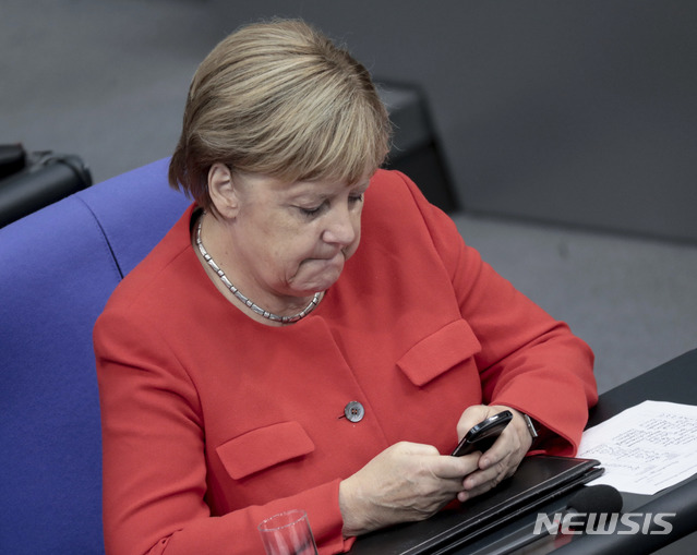 메르켈 통리가 2018년 9월 연방 하원 참석중 핸드폰을 들여다보고 있다 AP
