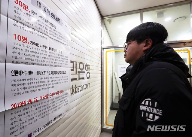【서울=뉴시스】김병문 수습기자 = 4일 오후 서울 중구 KB국민은행 남대문지점에서 시민이 오는 8일 국민은행 파업 가능성을 알리는 안내문을 보고 있다.&nbsp; 금일 국민은행 전 경영진은 총파업으로 인해 정상 영업이 불가능할 경우 사임하겠다고 밝혔다. 부행장, 전무, 상무, 본부본부장, 지역영업그룹 대표 등 경영진 54명은 허인 KB국민은행장에게 사직서를 일괄제출했다. 2019.01.04.&nbsp; dadazon@newsis.com 