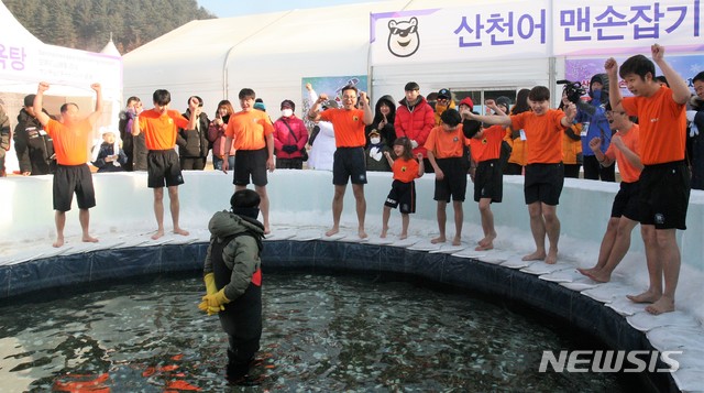 【화천=뉴시스】박종우 기자 = 2019 화천 산천어축제장 개막일인 5일 강원 화천군 화천읍 화천천 축제장에 마련된 체험장에서 방문객들이 산천어 맨손잡기에 나섰다. 2019.01.05    jongwoo425@newsis.com