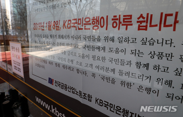 【서울=뉴시스】이영환 기자 = 7일 오전 서울 영등포구 여의도 KB국민은행 본점에 8일 파업 가능성을 알리는 안내문이 붙어 있다.7일 은행권에 따르면 국민은행 허인 행장과 박홍배 노조위원장 등 노사는 전날 오후 7시부터 이날 새벽 4시까지 임금·단체협상(임단협)을 진행했으나 주요 쟁점을 놓고 접점을 찾지 못했다. 노조가 이날 저녁 잠실 학생체육관에서 총파업 전야제를 열 계획인 가운데 오전부터 이뤄지는 이번 협상이 분수령이 될 전망이며, 총파업 돌입시 고객 불편은 물론 부정적 여론이 커질 수 있는 점 등을 감안해 극적 타결이 이뤄질 가능성도 배제할 수 없다. 2019.01.07. 20hwan@newsis.com