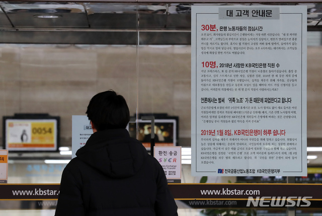 【서울=뉴시스】이영환 기자 = 7일 오전 서울 영등포구 여의도 KB국민은행 본점에 8일 파업 가능성을 알리는 안내문이 붙어 있다. 7일 은행권에 따르면 국민은행 허인 행장과 박홍배 노조위원장 등 노사는 전날 오후 7시부터 이날 새벽 4시까지 임금·단체협상(임단협)을 진행했으나 주요 쟁점을 놓고 접점을 찾지 못했다.&nbsp; 노조가 이날 저녁 잠실 학생체육관에서 총파업 전야제를 열 계획인 가운데 오전부터 이뤄지는 이번 협상이 분수령이 될 전망이며, 총파업 돌입시 고객 불편은 물론 부정적 여론이 커질 수 있는 점 등을 감안해 극적 타결이 이뤄질 가능성도 배제할 수 없다. 2019.01.07.&nbsp; 20hwan@newsis.com