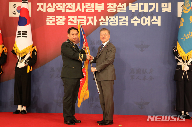【서울=뉴시스】전신 기자 = 문재인 대통령이 8일 청와대 영빈관에서 김운용 지상작전사령관에게 지상작전사령부 창설 부대기를 수여하고 있다. 2019.01.08.&nbsp; photo1006@newsis.com