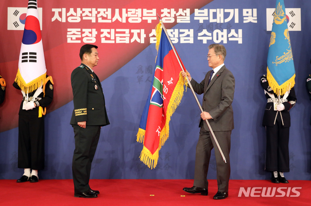 【서울=뉴시스】전신 기자 = 문재인 대통령이 8일 청와대 영빈관에서 김운용 지상작전사령관에게 지상작전사령부 창설 부대기를 수여하고 있다. 2019.01.08. photo1006@newsis.com