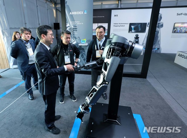 【서울=뉴시스】9일(현지시각) 미국 라스베이거스에서 열리고 있는 CES 2019에서 LG전자 노진서 로봇사업센터장과 네이버랩스 석상옥 헤드가 네이버 부스에 전시된 로봇팔 엠비덱스를 살펴보고 있다. 2019.01.10. (사진=네이버 제공)&nbsp; photo@newsis.com