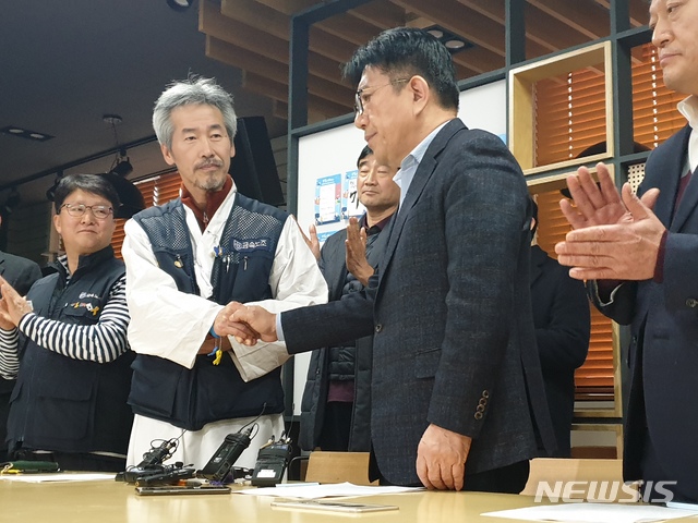 【서울=뉴시스】금속노조 파인텍지회 차광호 지회장(왼쪽)과 김세권 스타플렉스 대표가 노사협상 합의서에 서명 후 악수하고 있다. 