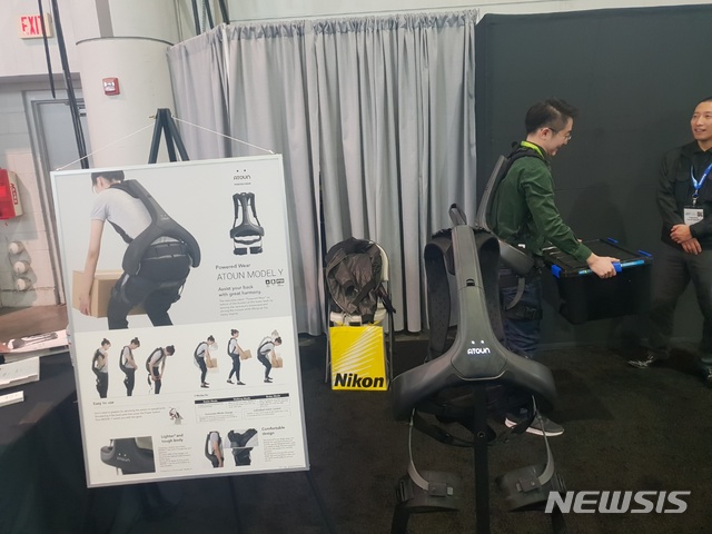 【라스베이거스=뉴시스】고은결 기자 = 지난 8일(현지시간) 미국 라스베이거스에서 개막한 'CES 2019'에 참가한 일본 업체 아토운(ATOUN) 부스 전경. 웨어러블 로봇을 입은 관람객이 직원의 도움을 받아 성능을 시험하고 있다. 2019.01.09. keg@newsis.com 