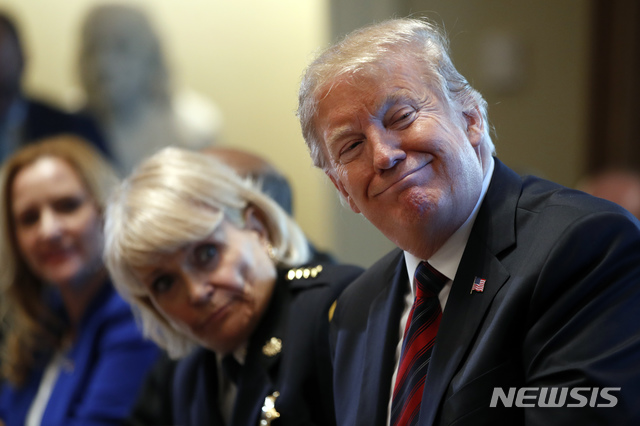  【워싱턴=AP/뉴시스】도널드 트럼프(왼쪽) 미 대통령이 11일(현지시간) 백악관 캐비닛룸에서 열린 국경 치안 관련 지역 사회 지도자들과의 토론회 중 참석자의 발언을 들으며 웃고 있다.  국경 치안 및 지역사회 안전 문제 등을 논의한 이 자리에서 트럼프 대통령은 해결책으로 국가비상사태 선포를 언급했지만 서두르지는 않겠다고 말했다. 2019.01.12. 