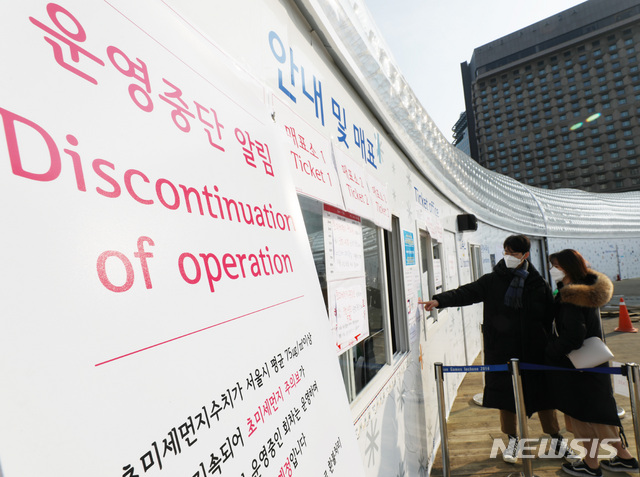 【서울=뉴시스】박미소 수습기자 = 서울에 초미세먼지주의보가 내린 12일 오후 서울 중구 서울광장 스케이트장 매표소 앞에 시민들이 스케이트장 운영중단 안내문을 바라보고 있다. 서울시는 12일 낮 12시를 기준으로 초미세먼지주의보를 발령했다. 2019.01.12. misocamera@newsis.com