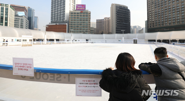【서울=뉴시스】박미소 수습기자 = 12일 오후 초미세먼지주의보로 인해 운영이 중단된 서울 중구 서울광장 스케이트장을 시민들이 바라보고 있다. 서울시는 12일 낮 12시를 기준으로 초미세먼지주의보를 발령했다. 2019.01.12. misocamera@newsis.com