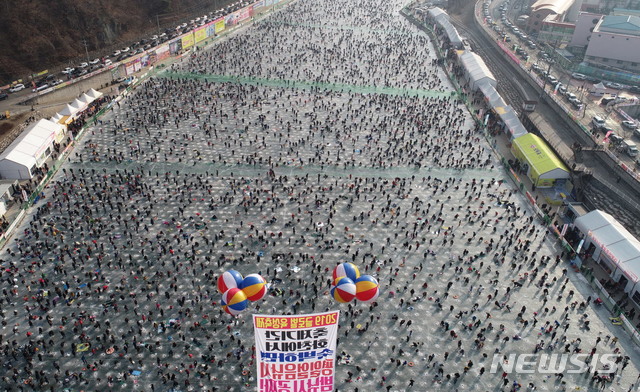 【화천=뉴시스】한윤식 기자 = 강원 화천산천어축제가 13년 연속 100만명의 관광객을 돌파한 13일 오후 관광객들이 화천군 화천천 얼음벌판에서 얼음낚시를 즐기고 있다. 2019.01.13. ysh@newsis.com&nbsp;&nbsp;&nbsp; 