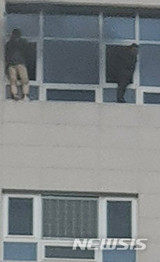 【천안=뉴시스】함형서 기자 = 14일 오후 4시 56분께 충남 천안시 서북구 쌍용동의 다중이용시설인 라마다앙코르 호텔에서 불이난 가운데 시민 2명이 창문 밖 난간을 밟고 구조대원을 기다리고 있다. 2019.01.14. (사진=독자 제공) photo@newsis.com 