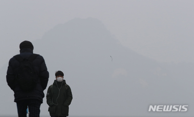 【서울=뉴시스】박미소 수습기자 = 3일째 수도권 미세먼지 비상저감조치가 발령 중인 15일 오전 서울 종로구 광화문 광장에서 한 시민이 미세먼지 마스크를 쓰고 발걸음을 옮기고 있다. 2019.01.15.&nbsp; misocamera@newsis.com