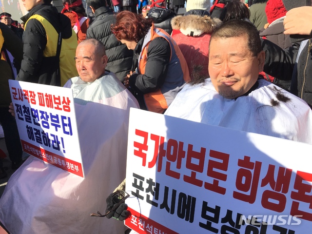 【의정부=뉴시스】배성윤 기자 = 16일 오후 서울 광화문 광장에서 열린 '포천시 전철 7호선 예비타당성조사 면제 촉구 1만명 결의대회'에서 참가자들이 삭발을 하고 있다. 2019.01.16.(사진=포천시청 제공)&nbsp; photo@newsis.com 