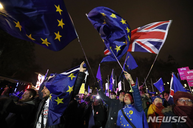  【런던=AP/뉴시스】브렉시트에 반대하는 영국 시위자들이 15일(현지시간) 런던에서 테리사 메이 총리의 브렉시트 합의안이 의회에서 부결됐다는 소식에 영국과 유럽연합(EU) 깃발을 흔들고 있다. 의회의 합의안 부결로 물품 공급 부족을 우려한 영국 기업들이 앞다퉈 물품 비축에 나서고 있다. 2019.1.16 