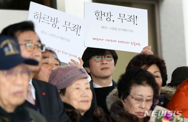 【제주=뉴시스】우장호 기자 = 17일 오후 제주지방법원 제2형사부 제갈창 부장판사 심리로 열림 재심 사건 재판에서 제주 4.3 생존수형인들이 공소기각 판결을 선고받았다. 재판이 끝난 후 임재성(39) 변호사가 '할망, 무죄'라고 적힌 피켓을 들고 대열 맨 뒤에 서있다. 2019.01.17. woo1223@newsis.com