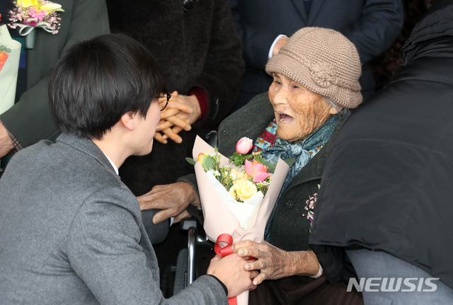 【제주=뉴시스】우장호 기자 = 17일 오후 제주지방법원 제2형사부 제갈창 부장판사 심리로 열림 재심 사건 재판에서 제주 4·3 생존수형인들이 공소기각 판결을 선고받았다. 재판이 끝난 후 임재성(39) 변호사에게 꽃다발을 건네받은 한 재심청구인이 환하게 웃고 있다. 2019.01.17. woo1223@newsis.com