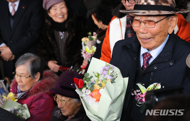 【제주=뉴시스】우장호 기자 = 17일 오후 제주지방법원 제2형사부 제갈창 부장판사 심리로 열림 재심 사건 재판에서 제주 4.3 생존수형인들이 공소기각 판결을 선고받았다. 꽃다발을 건네받은 4.3 생존수형인들이 환하게 웃고 있다. 2019.01.17. woo1223@newsis.com