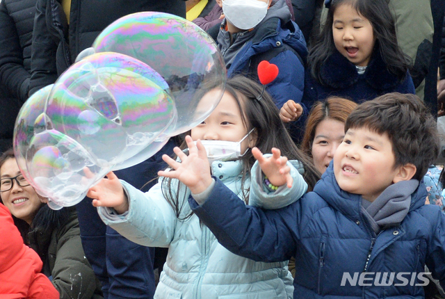 【전주=뉴시스】김얼 기자= 완연한 겨울 날씨를 보인 19일 전북 전주시 전주한옥마을 역사관 마당에서 버블 마술공연이 실시된 가운데 시민과 관광객들이 비눗방울을 터트리며 즐거운 주말을 보내고 있다. 2019.01.19.pmkeul@newsis.com
