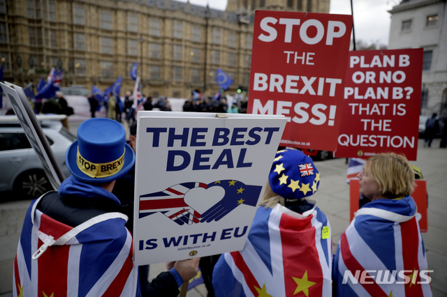 【런던=AP/뉴시스】21일(현지시간) 영국 런던의 의사당 앞에서 브렉시트에 반대하는 시민들이 플래카드를 들고 시위하고 있다. 테리사 메이 총리는 영국에 머물기를 원하는 유럽연합(EU) 시민들이 거주자 지위 신청 시 내는 수수료를 없앴고 유럽의회는 영국과 EU 간 협의가 이뤄지고 있다며 이를 환영했다. 한편 미셸 바르니에 EU 브렉시트 협상대표는 메이 총리가 브렉시트를 위해 영국 의회가 아닌 EU와의 긴밀한 관계에 집중해야 할 것이라고 충고했다. 2019.01.22.