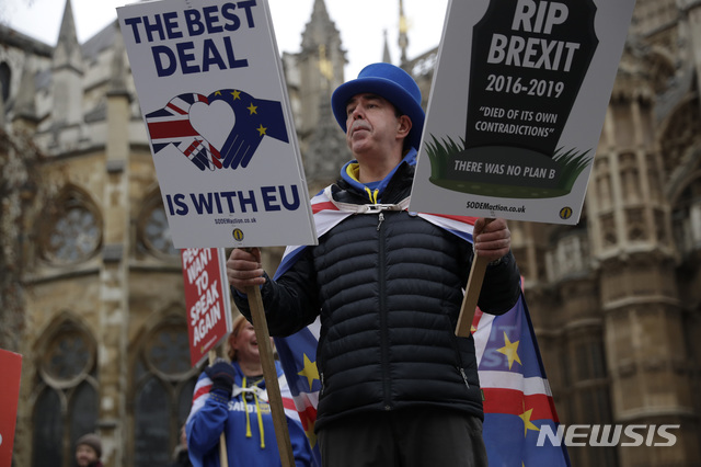  【런던=AP/뉴시스】21일(현지시간) 영국 런던의 의사당 앞에서 브렉시트에 반대하는 한 남성이 플래카드를 들고 시위하고 있다.&nbsp; 테리사 메이 총리는 영국에 머물기를 원하는 유럽연합(EU) 시민들이 거주자 지위 신청 시 내는 수수료를 없앴고 유럽의회는 영국과 EU 간 협의가 이뤄지고 있다며 이를 환영했다.&nbsp; 한편 미셸 바르니에 EU 브렉시트 협상대표는 메이 총리가 브렉시트를 위해 영국 의회가 아닌 EU와의 긴밀한 관계에 집중해야 할 것이라고 충고했다. 2019.01.22. 