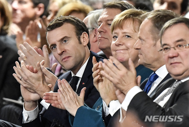 【아헨(독일)=AP/뉴시스】에마뉘엘 마크롱 프랑스 대통령(앞줄 왼쪽)과 앙겔라 메르켈 독일 총리(오른쪽 3번째), 도날트 투스크 유럽연합(EU) 정상회의 상임의장(오른쪽 2번째)이 22일(현지시간) 독일 아헨에서 독일과 프랑스 간 새 우호협력조약에 조인한 뒤 박수치고 있다. 양국은 이날 외교·국방 분야에서 협력을 강화하는 한편 독일이유엔 안보리 상임이사국이 되도록 프랑스가 협력한다는 아헨조약에 조인했다. 2019.1.23