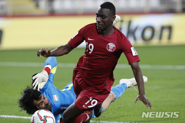 Iraq's goalkeeper Jalal Hassan clears the ball ahead of Qatar's forward Almoez Ali during the AFC Asian Cup round of 16 soccer match between Qatar and Iraq at Al Nahyan Stadium in Abu Dhabi, United Arab Emirates, Tuesday, Jan. 22, 2019. (AP Photo/Hassan Ammar)