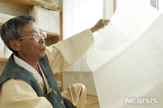  【문경=뉴시스】김진호 기자 = 경북도 무형문화재인 김삼식 한지장이 문경전통한지를 살펴보고 있다. 2019.01.24 (사진=문경시 제공) photo@newsis.com  