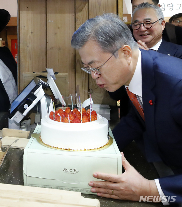 【대전=뉴시스】전신 기자 = 전국경제투어로 대전을 방문한 문재인 대통령이 24일 대전의 명물 성심당 빵집에서 튀김 소보로를 구매한 후 직원들로부터 받은 깜짝 생일 축하 케이크의 촛불을 끄고 있다. 2019.01.24. photo1006@newsis.com