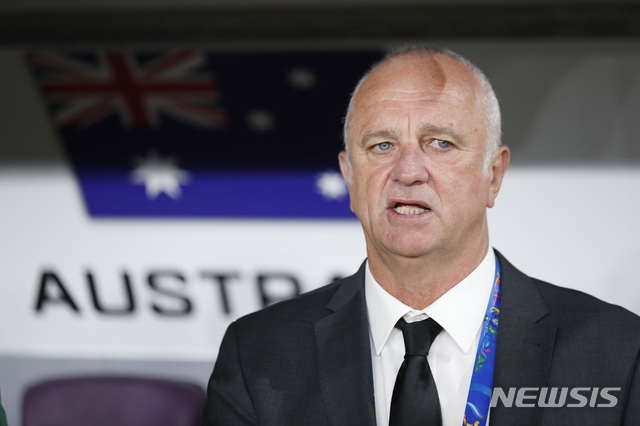 Australia's head coach Graham Arnold sings the national anthem at the start of the AFC Asian Cup quarterfinal soccer match between United Arab Emirates and Australia at Hazza Bin Zayed Stadium in Al Ain, United Arab Emirates, Friday, Jan. 25, 2019. (AP Photo/Hassan Ammar)