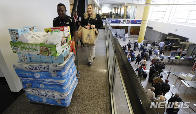 【시애틀(미 워싱턴주)=AP/뉴시스】시애틀의 타코마 국제공항에서 셧다운 기간중에 무급으로 일한 직원들을 위한 기증품을 끌고 보안구역으로 들어오는 직원들. 도널드 트럼프 대통령이 25일 셧다운 잠정해제를 선언하면서 각 공항의 보안검색대도 정상을 되찾았고 미교통안전위원회( NTSB)의 중단되었던 교통사고 조사도 28일부터 재개되었다. 2019.01.29&nbsp; 