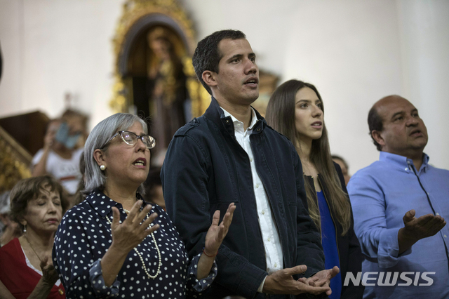 【카라카스 ( 베네수엘라) = AP/뉴시스】 베네수엘라의 임시대통령임을 선언한 후안 과이도가 27일(현지시간) 부인 파비아나 로살레스( 오른쪽 두번째)와 함께 시위 희생자를 위한 미사에 참석하고 있다.