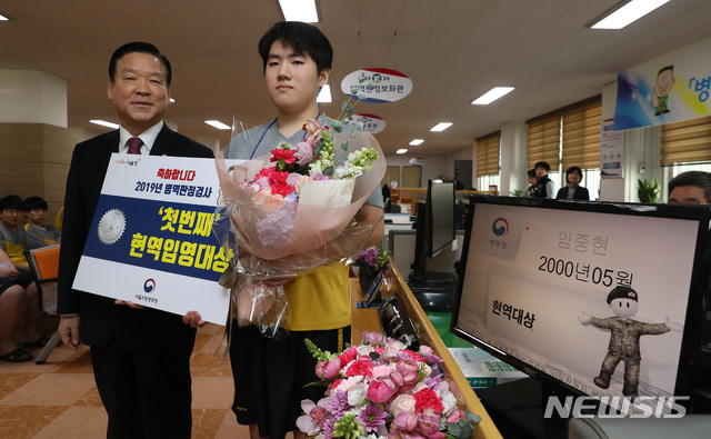 【서울=뉴시스】고승민 기자 = 기찬수 병무청장이 올해 첫 병역판정검사가 실시된 28일 오전 서울 영등포구 여의대방로 서울지방병무청 제1병역판정검사장에서 첫 번째 현역입영대상자로 선정된 임중현 씨와 기념촬영을 하고 있다. 2019.01.28. photo@newsis.com