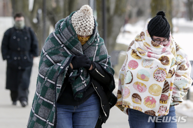 【오마하=AP/뉴시스】북극 한파로 미 중서부와 중북부 지역에 기록적인 한파가 몰아친 가운데 30일(현지시간) 미 네브래스카주 네브래스카-오마하 대학 캠퍼스에서 행인들이 담요로 몸을 감은 채 걷고 있다. 최소 7명이 숨진 기록적 한파로 학교와 직장은 폐쇄됐고 우편 서비스도 이례적으로 일부 우편물 배달이 중단됐다.이번 한파는 제트기류의 변화로 평소보다 남하한 극 소용돌이가 원인으로 파악되고 있다. 2019.01.31. 